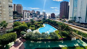 A residential area with a swimming pool surrounded by greenery and tall buildings in the background. - A29 - Wonderful urbanization in Cala de Finestrat (Cala de Finestrat)