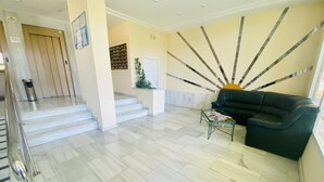 A modern lobby with a staircase, a black leather sofa, and a glass coffee table. - A29 - Wonderful urbanization in Cala de Finestrat (Cala de Finestrat)
