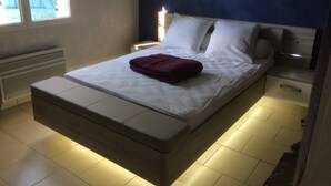 Un dormitorio moderno con cama, mesitas de noche y mesilla.