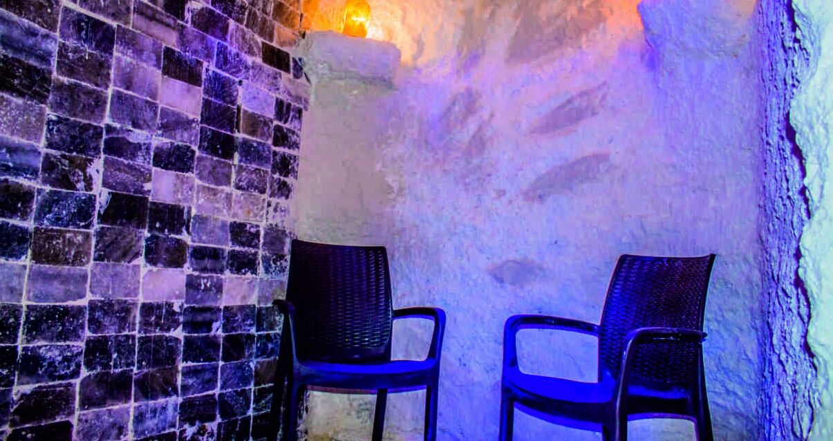 Una habitación con pared de ladrillo y dos sillas.