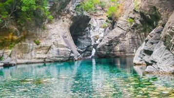 Una formación rocosa natural con una piscina de agua cristalina.