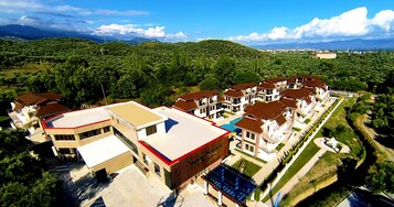 Zona residencial con varias casas de dos pisos, una piscina y un paisaje montañoso al fondo.