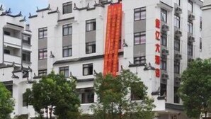 A multi-story building with a prominent red banner. - Jinyi Hotel (Sanming)