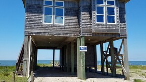 A wooden lifeguard tower with a covered entrance and a clear view of the beach and ocean. - Hooligan Sunset:  Waterfront deck, sunsets, private boat dock. (Ocracoke)
