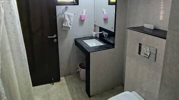 A bathroom with a toilet, sink, and mirror. There is a towel rack above the sink and a window above the mirror.