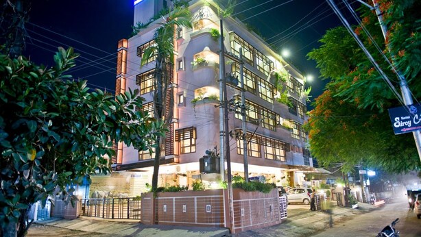 Un hotel de varios pisos con un diseño moderno, con balcones y una fachada bien iluminada.