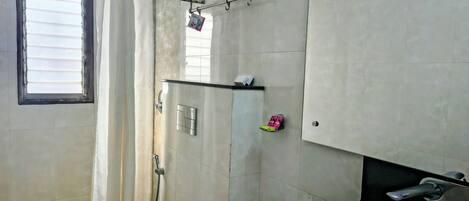 A bathroom with a toilet, a sink, a shower, and a towel rack.