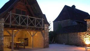 A rustic stone building with a wooden balcony and a pool area. - Rent Gite Casalissa house with heated pool in Perigord Noir, Sarlat (Castels)