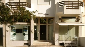 A building with a central entrance, a small outdoor seating area, and a staircase leading to an upper level. - 6th floor apartment, facing the sea with balcony "exceptional 360 ° view" (Portimão)