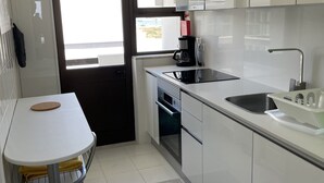 A modern kitchen with white cabinets, a coffee maker, a sink, and a window with a view. - 6th floor apartment, facing the sea with balcony "exceptional 360 ° view" (Portimão)