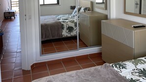 A bedroom with a bed, a dresser, a mirror, and a sliding door leading to another room. - 6th floor apartment, facing the sea with balcony "exceptional 360 ° view" (Portimão)