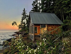 A coastal cabin with a metal roof, wooden walls, and a porch overlooking the sea. - Artisan-crafted Magic on Lake Superior (Lutsen)