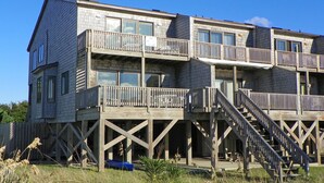 Un immeuble à plusieurs étages, doté de balcons en bois et d’un escalier menant aux niveaux supérieurs.