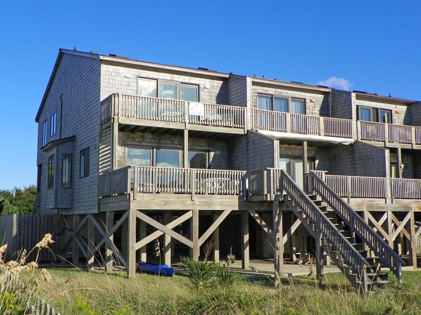 A multi-story building with wooden balconies and a staircase leading to the upper levels.