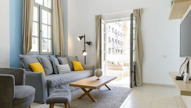 A modern living room with a grey sofa, a wooden coffee table, and a grey armchair. - Sweethome26 - Hayarkon with Terrace (Tel Aviv)