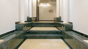 A marble staircase leading to a door, flanked by white columns and a light-colored floor. - Sweethome26 - Hayarkon with Terrace (Tel Aviv)