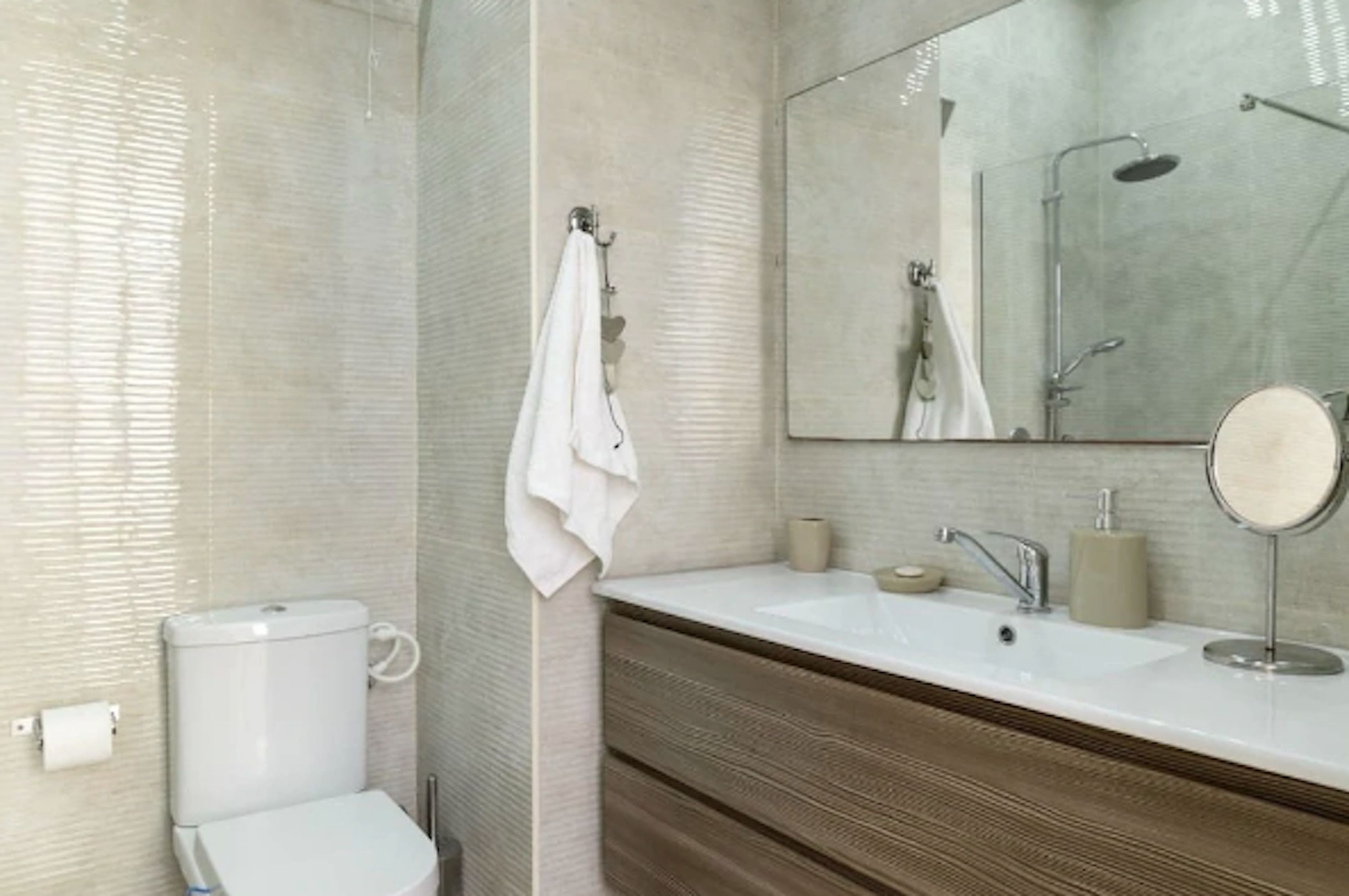 A modern bathroom with a toilet, sink, and shower.