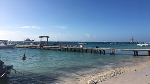 Un muelle con barcos amarrados, cielo despejado y aguas tranquilas.