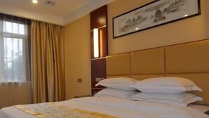 A hotel room with a large bed, a framed picture on the wall, and a window with curtains. - Greentree Alliance Hotel (Suzhou)