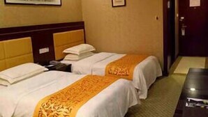 A hotel room with two beds, a wooden headboard, a small table, and a framed picture on the wall. - Greentree Alliance Hotel (Suzhou)