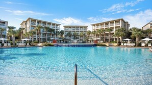 A large pool with lounge chairs and umbrellas, surrounded by multi-story buildings with balconies. - Seacrest Beach Home + Dog Friendly, Tram & Bikes (Seacrest Beach)