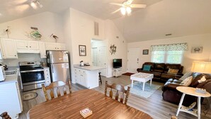 A spacious living area with a dining table, kitchen, and seating area. - Blue Crab:  Spacious screened porch, short stroll to Ocracoke Coffee Co.. (Ocracoke)