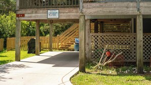 A wooden deck with a sign indicating rental availability. - Blue Crab:  Spacious screened porch, short stroll to Ocracoke Coffee Co.. (Ocracoke)