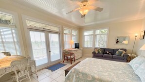 A bedroom with a bed, a desk, a chair, a sofa, and a ceiling fan. - Sea View: Rooftop deck with spectacular views. (Ocracoke)