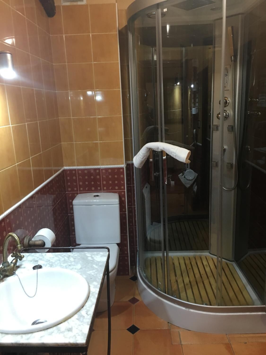 A bathroom with a glass-enclosed shower, a toilet, and a sink.