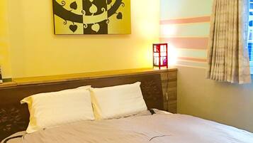 Una habitación de hotel con una cama grande, aire acondicionado instalado en la pared y una ventana con cortinas.