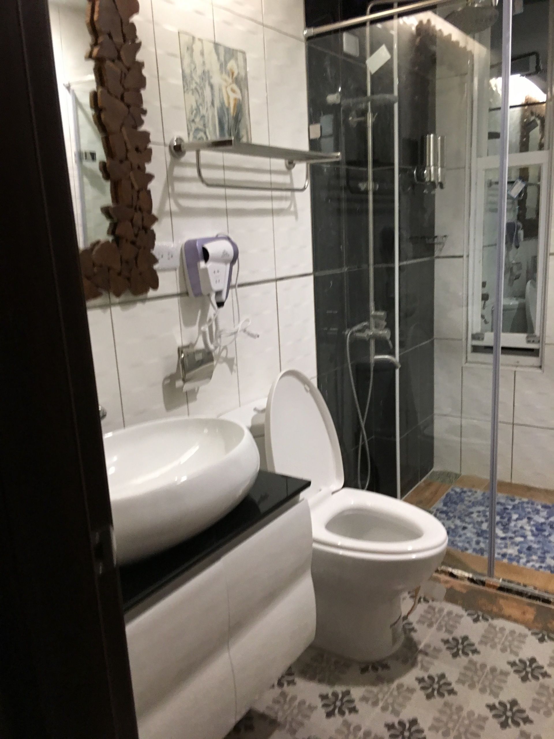 Un baño con lavamanos blanco, inodoro y cabina de ducha de vidrio.