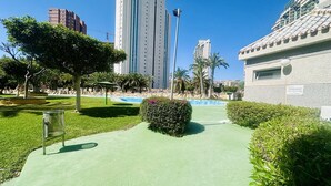 A pathway leading to a building with a tiled roof, surrounded by greenery and palm trees. - A45 - Fantastic urbanization close to the beach (Cala de Finestrat)