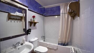 Een badkamer met een wastafel, toilet en bad.