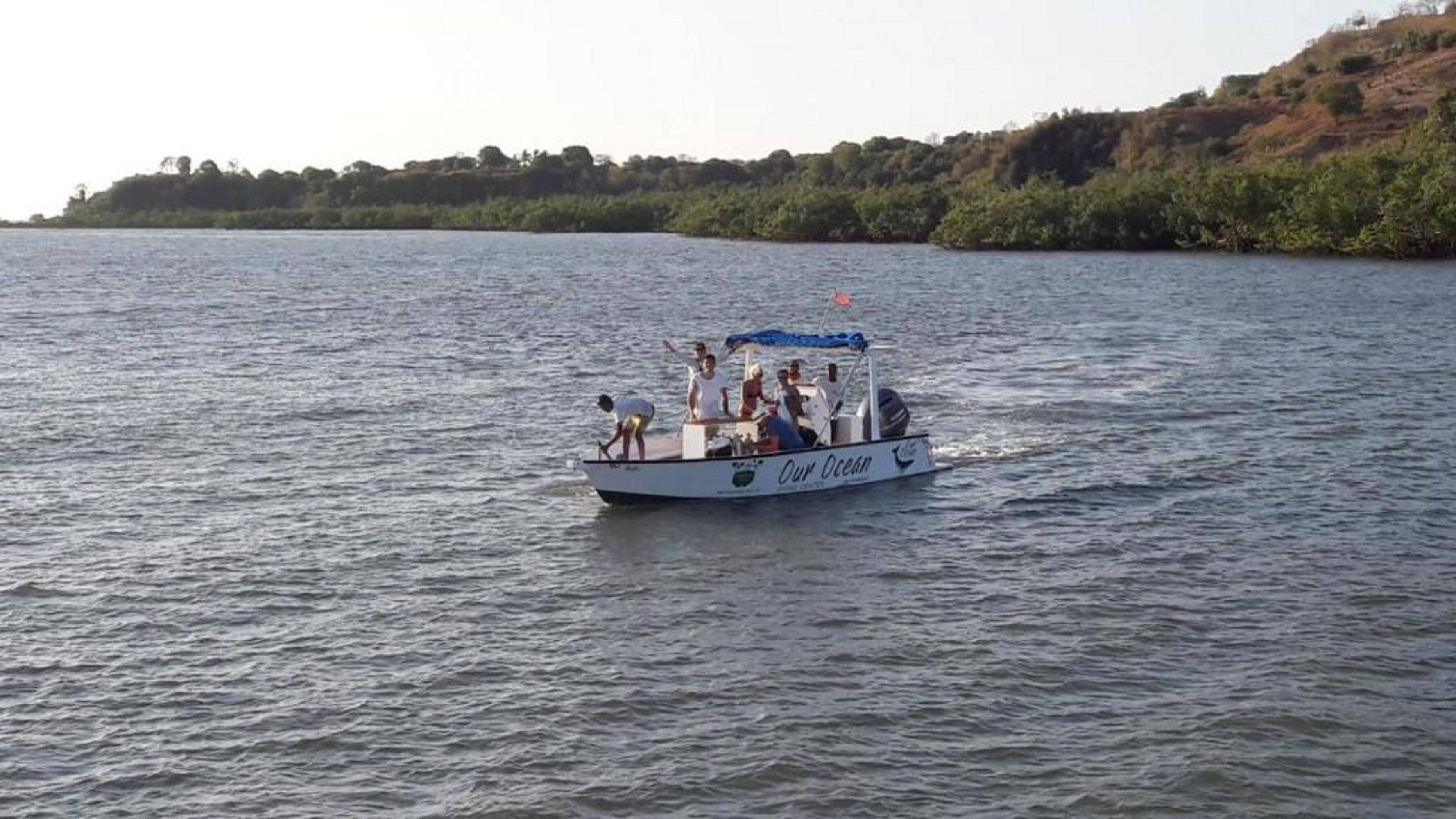 Un barco con el texto 'Our Ocean' en su costado, navegando sobre el agua.
