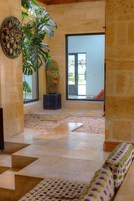 Un interior moderno con una planta grande, una escultura colorida y vistas al exterior.