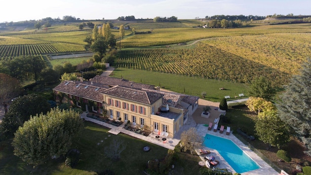 A large estate with a swimming pool, surrounded by lush gardens and vineyards. - Chateau du Palanquey & SPA (Sainte-Colombe)