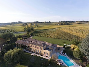 Un vaste domaine doté d’une piscine, entouré de jardins luxuriants et de vignobles.