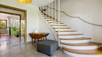 Ein modernes Interieur mit einer Wendeltreppe, einem runden Tisch und einer Bank.