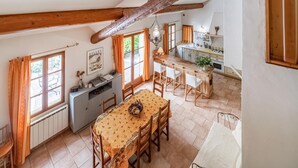 A spacious kitchen with a dining area, wooden beams, and a view of the outdoors. - Gorgeous home in Pernes les Fontaines (Pernes les Fontaines)