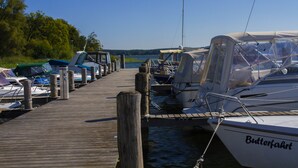 A wooden dock with boats moored at the end. - Seehotel Plau Am See (Plau am See)