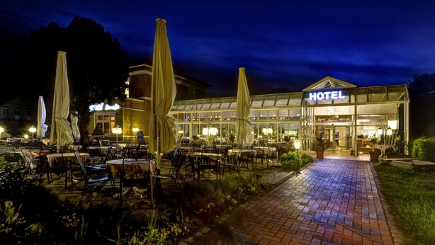 A hotel with outdoor seating and a well-lit entrance. - Seehotel Plau Am See (Plau am See)