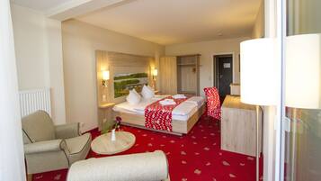 Een hotelkamer met een bed, een stoel, een klein tafeltje en een lamp.