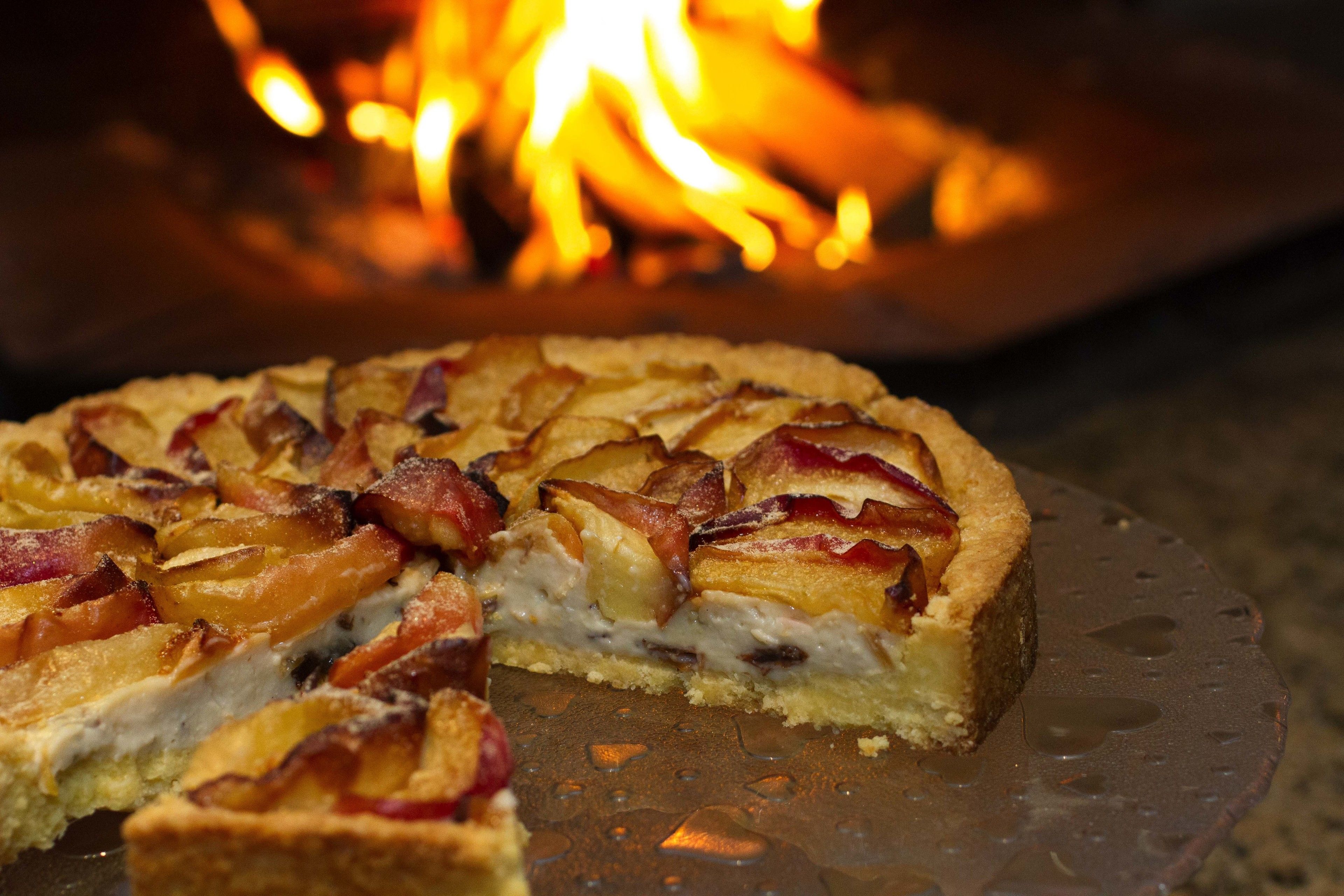 Tarta de manzana con rodajas de manzana y tocino sobre un plato de vidrio.