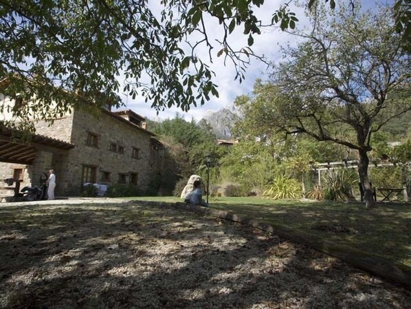 A rustic stone building with a courtyard, surrounded by trees and vegetation. - La Yosa de Argüebanes (Camaleno)
