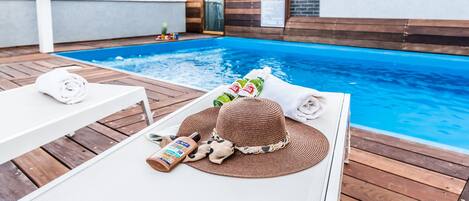 Een buitenzwembad, parasols voor strand/zwembad