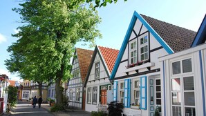 Eine typische europäische Straße mit engen Kopfsteinpflasterwegen und Fachwerkhäusern mit blauen Fensterläden.