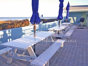 Enjoy a meal under the shade of a blue umbrella at one of our outdoor tables overlooking the water.