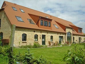 Un bâtiment à deux étages, doté d’un toit en pente, de nombreuses fenêtres et d’une pelouse bien entretenue.