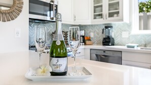 A kitchen with white cabinets, a microwave, and a coffee maker. - Luxury cottage, private, saltwater spa🌺walk to beach, dining,shops (Kihei)