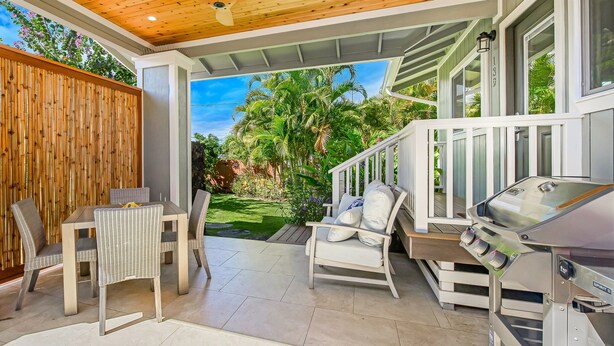 An outdoor patio with a dining table and chairs, a grill, and a view of a lush garden. - Luxury cottage, private, saltwater spa🌺walk to beach, dining,shops (Kihei)